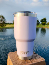 a white yeti cup sitting on top of a wooden post