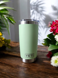 a green yeti cup sitting on top of a wooden table