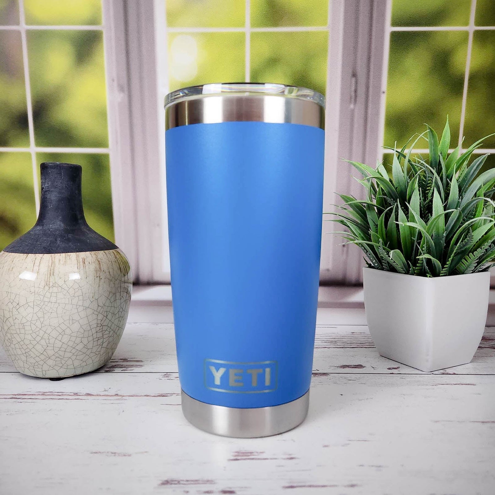 a blue yeti tumbler next to a potted plant