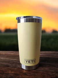 a yellow yeti cup sitting on top of a wooden table