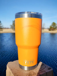 a yellow cup sitting on top of a wooden post