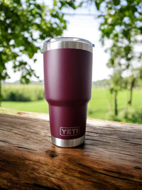 a red yeti cup sitting on top of a wooden table