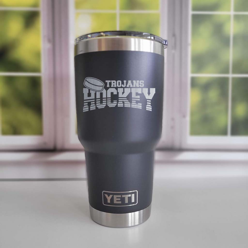 a black and silver yeti cup sitting in front of a window