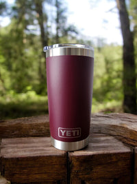 a red yeti cup sitting on top of a wooden table