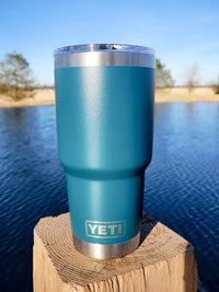 a blue yeti cup sitting on top of a wooden post